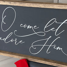 Load image into Gallery viewer, Decorative sign with white cursive text on a black board with wooden frame. O Come Let Us Adore Him