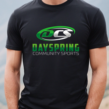 Load image into Gallery viewer, Person wearing a black t-shirt with Dayspring Community Sports logo against a mountainous background