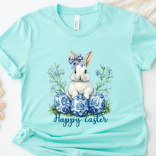 Load image into Gallery viewer, Ice blue t-shirt with a bunny and Easter eggs design on a white background