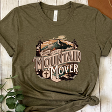 Load image into Gallery viewer, Green t-shirt with 'Mountain Mover' graphic design on a wooden surface.