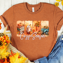 Load image into Gallery viewer, Autumn Bella Canvas  t-shirt with 'Cozy Season' graphic featuring pumpkins, a mug, and a truck on a wooden surface.