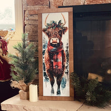 Load image into Gallery viewer, Framed artwork of a cow wearing a plaid scarf on a stone fireplace mantle.