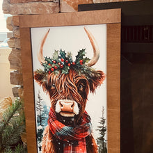 Load image into Gallery viewer, Framed artwork of a Highland cow with a wreath and plaid scarf against a stone wall.