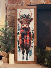 Load image into Gallery viewer, Framed artwork of a cow with a plaid scarf on a stone fireplace mantle.