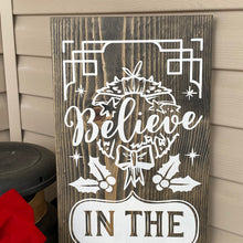 Load image into Gallery viewer, Wooden sign with Christmas-themed design and text &#39;Believe in the magic of Christmas&#39; on a wooden surface.