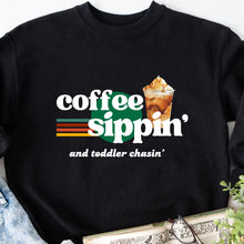 Load image into Gallery viewer, Stay cozy while chasing your little ones with the Coffee Sippin&#39; and Toddler Chasin&#39; sweatshirt or hoodie. Fuel up with your favorite brew and tackle the day with a playful attitude. Perfect for any busy parent who doesn&#39;t take themselves too seriously.