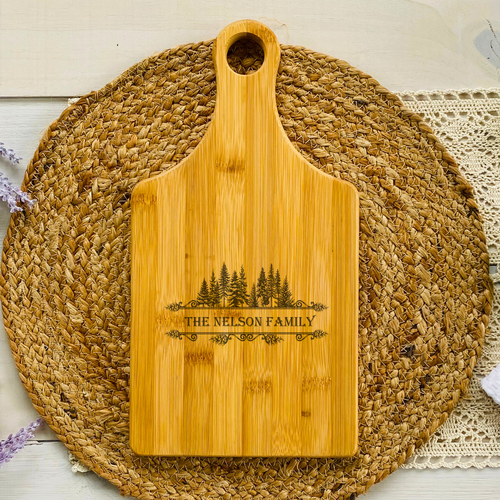 Personalized Bamboo Cutting Board With Family Name Framed With Pine Trees Paddle Shaped