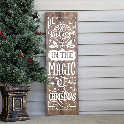 Wooden Christmas sign with decorative text Believe in the Magic of Christmas.