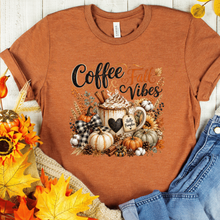 Load image into Gallery viewer, Coffee and Fall Vibes graphic T-shirt on an autumn colored Bella+Canvas tee, perfect for coffee lovers and autumn outfits.